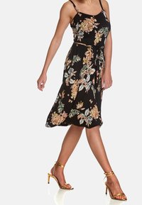 Černé bezramínkové šaty s květinovým potiskem v béžové, zelené a modré; stažený pas s nastavitelnou šňůrkou; lehký materiál a délka po kolena.