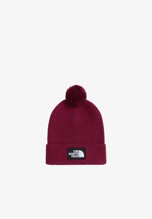 Ciemnoczerwona dziana czapka z pomponem na górze i czarno-białą naszywką z logo The North Face na mankiecie.