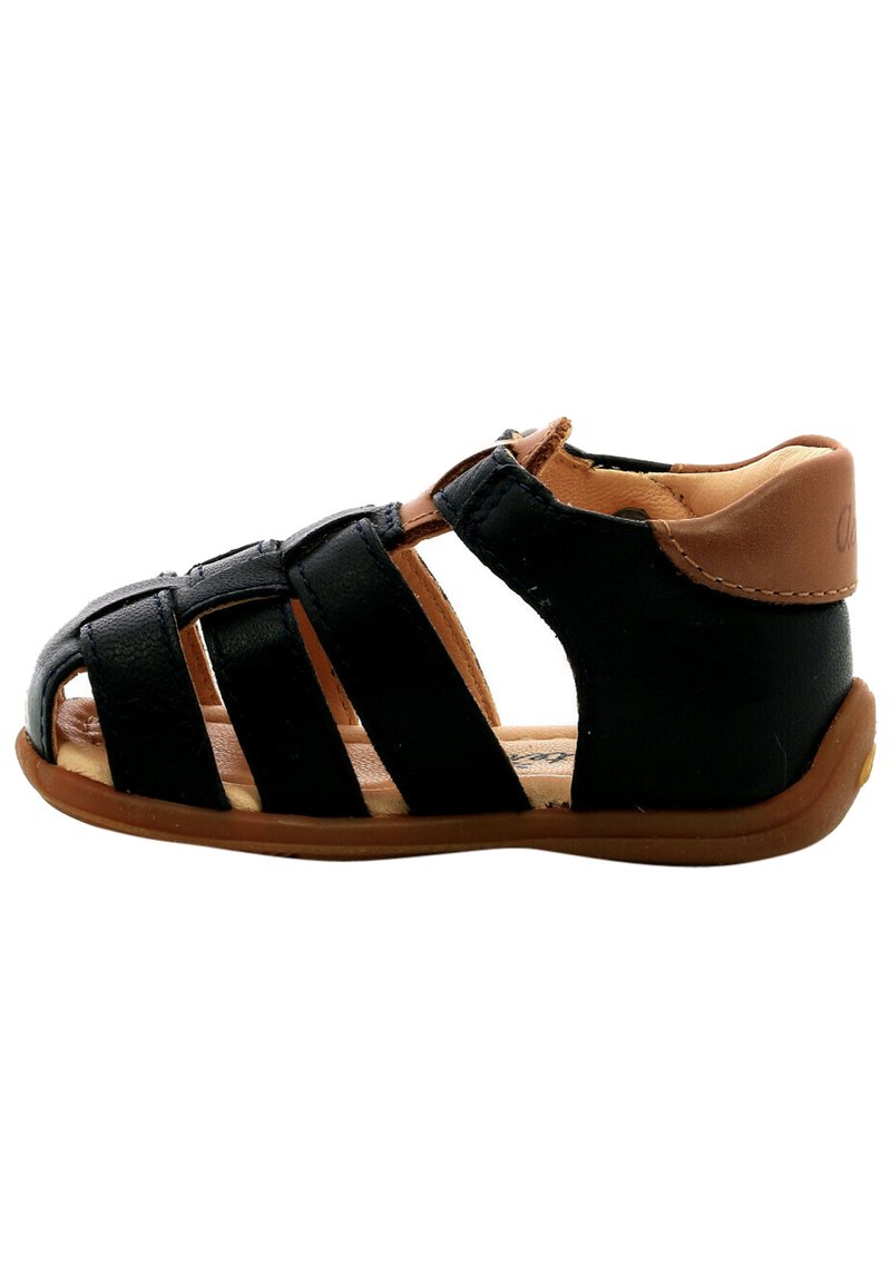 Sandal de cuero negro con diseño de punta abierta, múltiples tiras cruzadas y un talón trasero en color marrón. Suela de goma flexible para mayor comodidad.