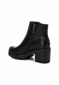 Botas negras hasta el tobillo de cuero liso, con cremallera lateral, tacón ancho y suela texturizada con patrón de relieve.