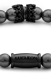 Svart perlesmykke med polerte hematittperler og utsmykkede svarte metalldetaljer, med en sentral gravert lås som viser "LUCELEON."