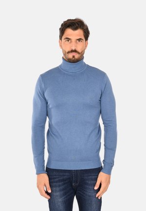 Maglione a collo alto di un blu chiaro, realizzato in morbido tessuto a maglia, design aderente con polsini e orlo a coste, indossato con jeans scuri.