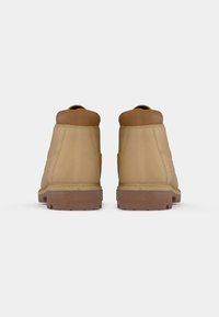 Brune lær ankle boots med brune accenter, rund tå, forsterket hæl, og gummi såle med hevede riller for godt feste.