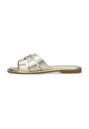 Sandali slip-on metallici oro con due ampie cinghie e un dettaglio decorativo a fibbia. Suola piatta con una base marrone chiaro. Texture liscia.