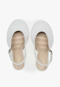 Witte leren slingback schoenen met ronde neuzen en een lage hak. Kenmerken zijn een zijgesp en een gladde, textuur geprofileerde binnenzool.