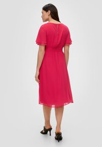 Rosa Chiffonkleid mit kurzen, ausgestellten Ärmeln und einem gerafften Bund. Es verfügt über einen Schlüsselverschluss im Rücken und ein knielanges, fließendes Design.