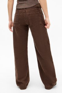 Brown corduroy wijde broek met verticale ribbels, voorzien van twee achterzakken en een relaxte pasvorm.