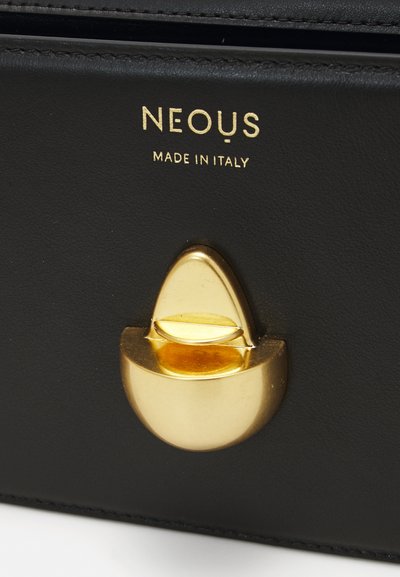 Black leather product featuring a gold hardware clasp with a rounded shape. "NEOUS" and "MADE IN ITALY" embossed above the clasp.