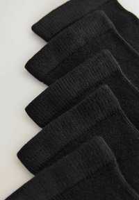 Viis paari musta soonikkoesokke, mille asetamine on vahelduv rida heledal pinnal.