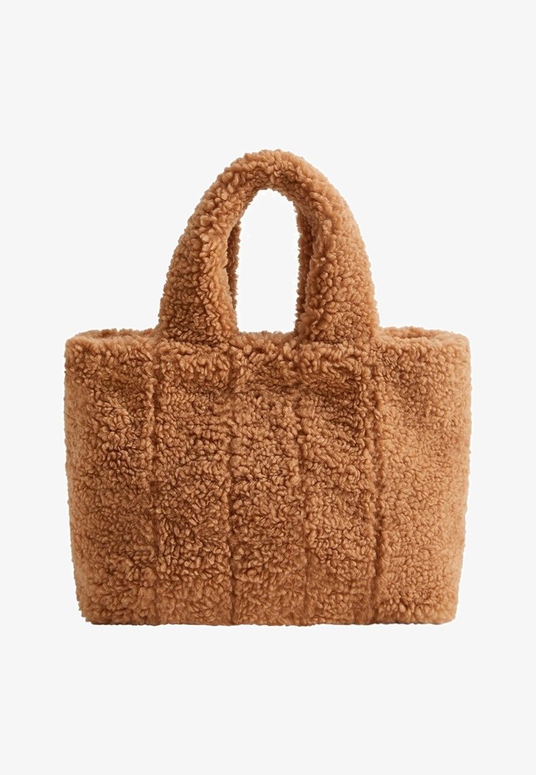 Sac fourre-tout en peluche teddy marron avec des poignées courtes rembourrées et une forme rectangulaire.
