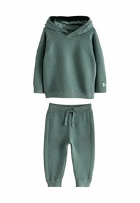 Groene geribde twee-delige outfit met een capuchon-top en broek met elastische tailleband, voorzien van een textuurpatroon en een relaxte pasvorm.
