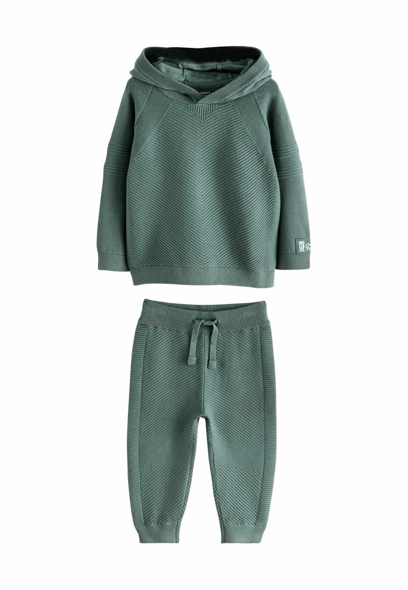 Groene geribde twee-delige outfit met een capuchon-top en broek met elastische tailleband, voorzien van een textuurpatroon en een relaxte pasvorm.