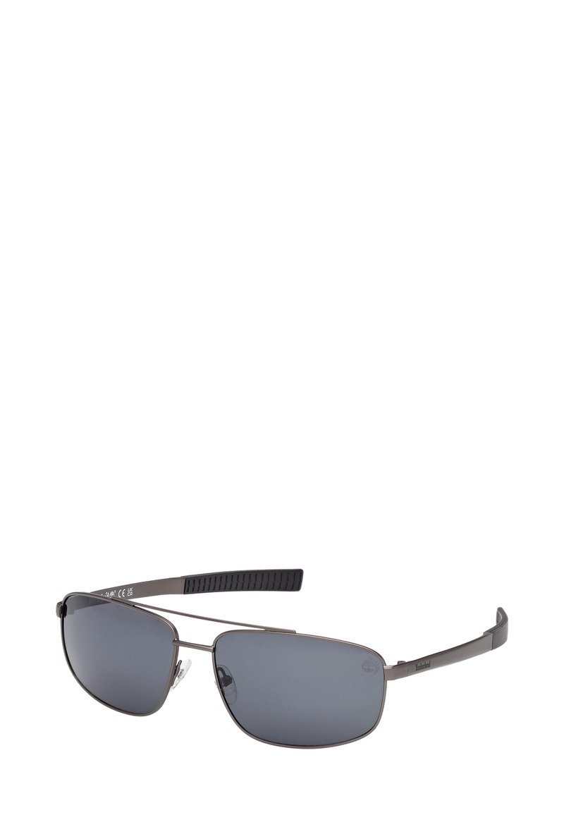 Sluneční brýle s kovovým rámem, obdélníkovými tmavými čočkami a černými texturovanými konektory ramínek, logo Timberland na pravém ramínku.