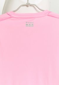 Rosa Sportshirt aus weichem Material, mit einem Etikett auf der Rückseite, das Größe und regionale Größenausschilderung zeigt, sauberes Design und ohne Muster.
