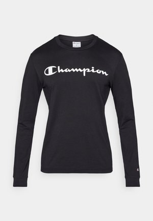 Musta pitkähihainen t-paita, valmistettu puuvillasta. Rintakeällä valkoinen "Champion"-logo. Sisältää resorireunaiset hihansuut ja pyöreän pääntien.