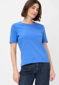 T-shirt blu a maniche corte in cotone, con scollo rotondo e orlo dritto. Accento notevole con piccolo logo sull'orlo inferiore.