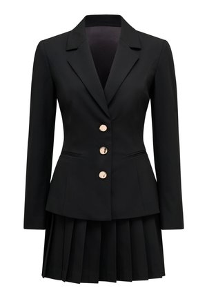 Musta räätälöity bleiseri, jossa on kolme kullanväristä nappia, yhdistettynä vastaavaan mustaan laskostettuun hameeseen, yhdistettynä yhtenäiseksi asukokonaisuudeksi.