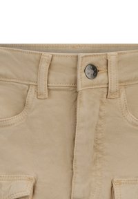 Pantaloni in cotone beige con una texture liscia, dotati di chiusura con bottone metallico, passanti per cintura e tasche frontali.