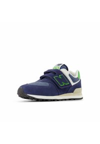 Tummansininen lenkkari, jossa on mokkanahkaa ja verkkomateriaaleja, vihreä yksityiskohta sivussa, tarranauha ja valkoinen välipohja. Musta kumipohja pitoa varten.