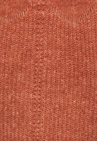 Tissu tricoté de couleur rouille avec une texture douce et duveteuse et un motif de côtes verticales visible.