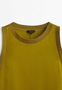 Haut sans manches vert olive avec un col rond côtelé, confectionné dans un tissu lisse. Dispose d'une étiquette au centre du dos. Pas de motifs visibles.