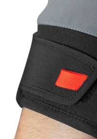 Zwarte stoffen polsband met rode accenten, met een gladde textuur en gestikte details, ontworpen voor flexibiliteit en comfort.