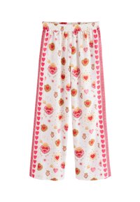 Pantalones blancos de pierna ancha con patrones de corazón sagrado en rojo y dorado y franjas laterales rojas bordeadas con corazones, con cintura elástica.