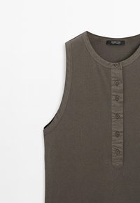 Bezrukávový, tmavě šedý top z měkké látky, s kulatým výstřihem a knoflíkovou légou se pěti knoflíky vpředu.