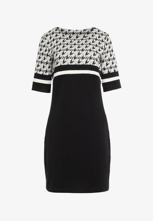 Czarna sukienka z wzorzystą szaro-skalną górą, z wzorem w zębatkę. Posiada okrągły dekolt i krótkie, podwinięte rękawy z białymi paskami.