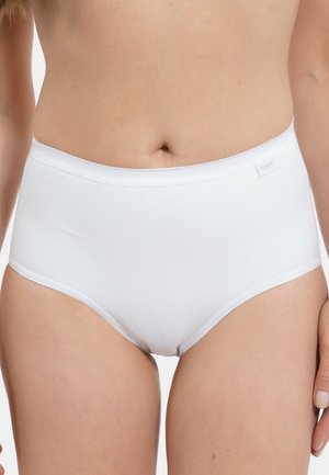 Woman wearing plain white high-waist briefs, standing against a white background, midsection and upper thighs visible.