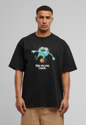 Sort bomulds t-shirt med korte ærmer, der har et tegneserieagtigt grafik af en grøn karakter og teksten "Tag mig ud, træner" i hvid.