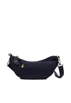 Křížová taška ve tvaru půlměsíce v námořnické modři s nastavitelným popruhem, zapínáním na zip a malou černo-zlatou visačkou na bílém pozadí.