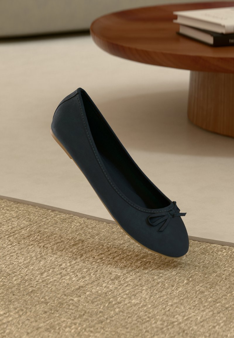 Ballerine blu navy realizzata in materiale liscio; presenta una punta rotonda e un piccolo fiocco decorativo sul davanti. La suola piatta aumenta il comfort.
