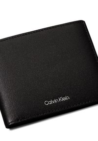 Portefeuille en cuir noir avec une finition texturée. Présente un design épuré et un logo "Calvin Klein" discret sur le devant.