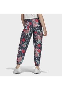 Blommiga joggerbyxor i mörknavy, med rosa, gröna och vita mönster; elastisk midja; rynkade muddar; lätt material.