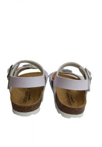 Sandali bianchi aperti sul retro con cinturini regolabili, plantare in sughero e suola bianca texture. Caratterizzati da una fibbia in metallo e materiale simile alla pelle liscia.