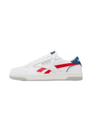 Witte lage Reebok sneaker met rode en blauwe accenten, vetersluiting en platte rubberen zool, zijaanzicht op een witte achtergrond.