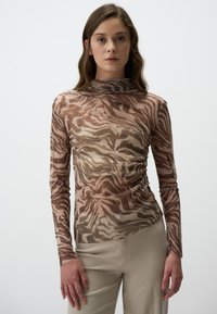 Haut à manches longues en tissu transparent avec un motif abstrait marron et beige, orné de légers paillettes, et au design col montant.