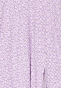 Tissu lavande avec petit motif de marguerite blanche, avec une couture verticale centrale et une petite fente à l'avant.