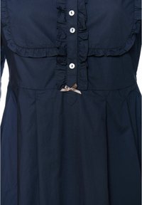 Tengerészkék pamut ruha fodros gallérral, gombos elülső résszel és egy kis barna szalag díszítéssel derékvonalban. Texturált anyag redőkkel.