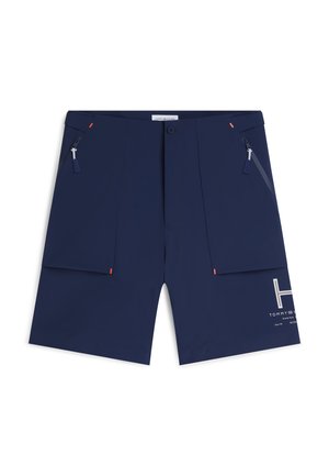 Pantalones cortos de hombre azul marino con cremallera frontal y cierre de botón, dos bolsillos laterales con cremallera y texto de logo blanco en la parte inferior de la pierna derecha.