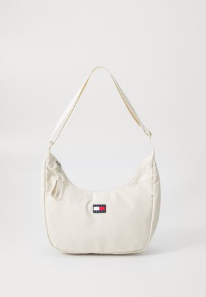 Borsa a spalla in nylon bianco con design curvo, caratterizzata da una patch con logo, dettagli con cerniera e una texture morbida e liscia. Inclusa tracolla regolabile.