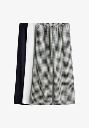 Tri páry nohavíc s elastickým pásom v čiernej, bielej a čierno-bielom károvanom vzore, zobrazené vedľa seba.