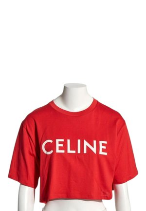 Czerwony krótki T-shirt z białym tekstem "CELINE" na przodzie, prezentowany na białym, bezgłowym torsie manekina.