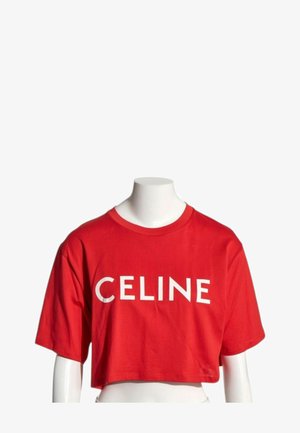 T-shirt rouge court à manches courtes avec texte blanc "CELINE" à l'avant, présenté sur un torse de mannequin blanc sans tête.