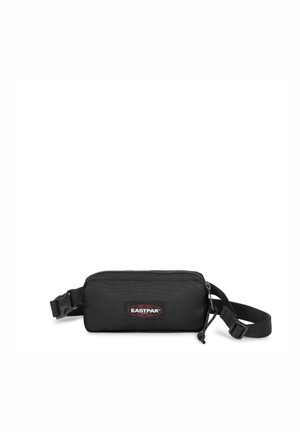 Bolsa Eastpak negra con forma rectangular, cierre de cremallera, correa ajustable y un parche de marca en la parte frontal. Fabricada con tejido duradero.