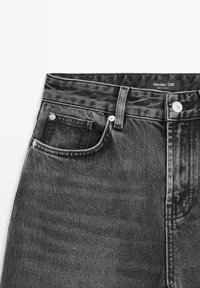 Černé džíny z denimu s klasickým designem pěti kapes. Obsahují malou přední kapsu, stříbrné kování a texturovanou nášivku na pase.