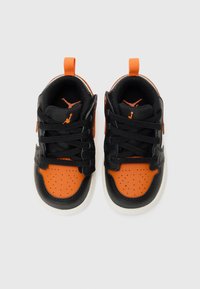 Black and orange athletic shoes with perforated design, flat laces, pull tab, and white rubber sole. Classic style, suitable for casual wear.