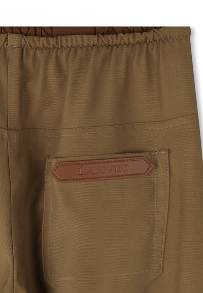 Khaki broeken van stevig materiaal, voorzien van een bruin leren logo patch op de achterzak en een elastische tailleband voor comfort.