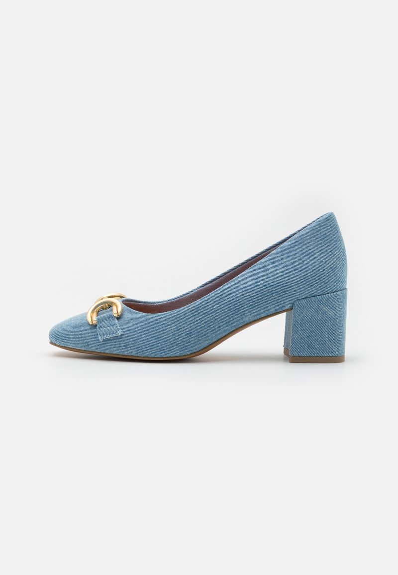 Chaussure en denim bleu à talon bloc bas, bout pointu et détail boucle dorée à l'avant.